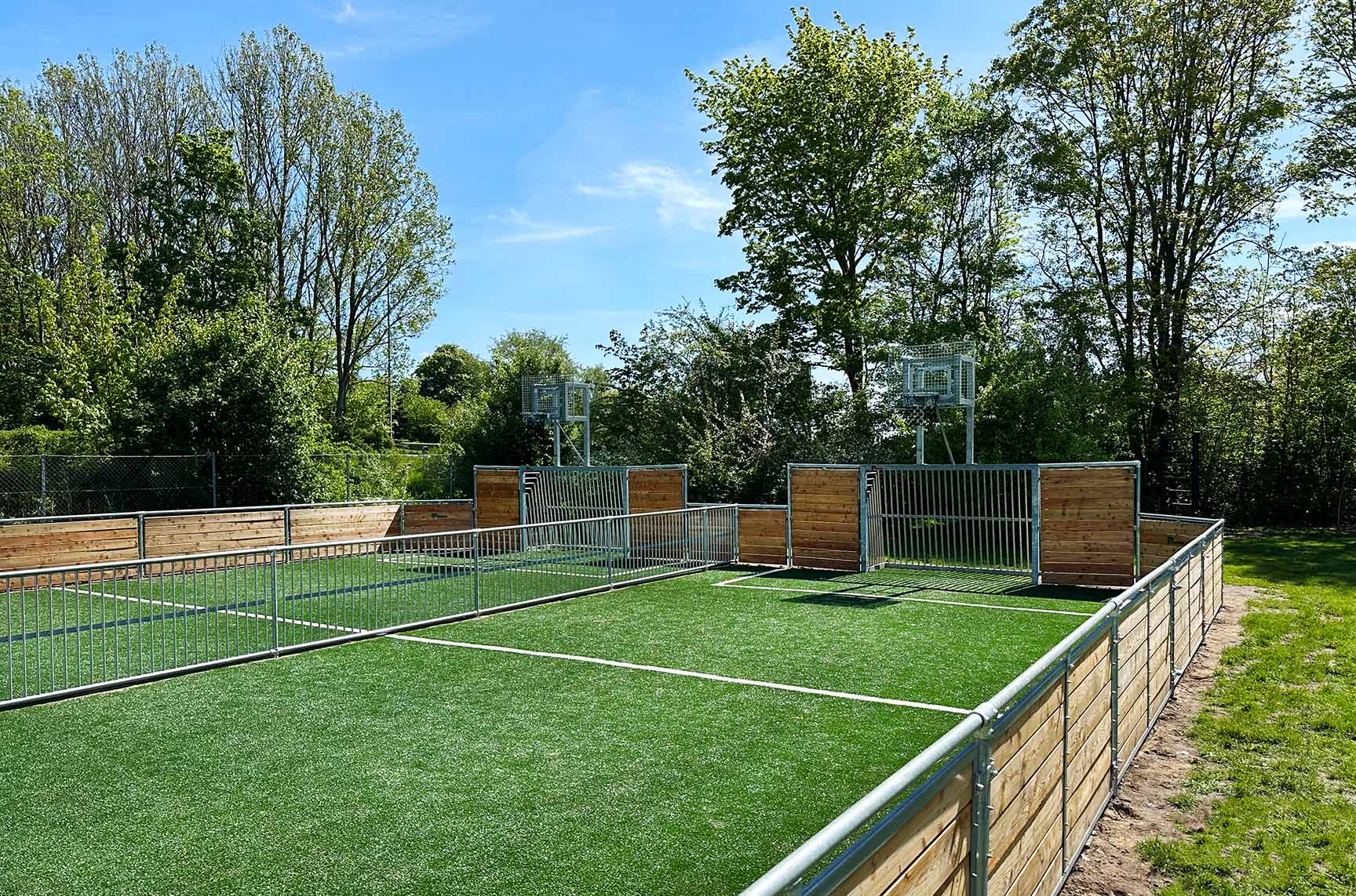 dobbelt multibane i træ med kunstgræs, fodboldmål og basketballstativer